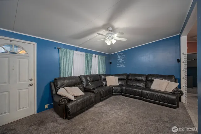 a living room with furniture and a ceiling fan