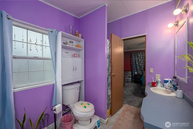 a bedroom with a bed and a flat tv screen on dresser