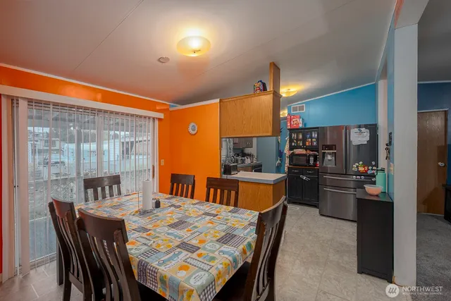 a kitchen with sink refrigerator dining table and chairs