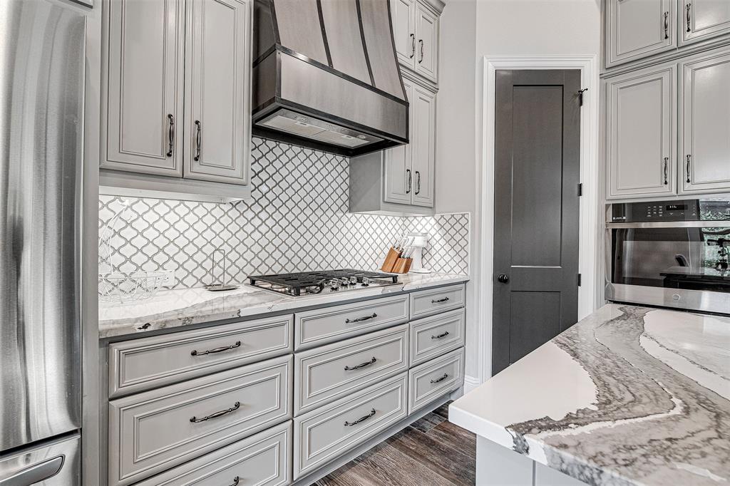 13924 East Riviera Drive Fort Worth, TX 76028 - Photo 11 of 38 a kitchen with granite countertop white cabinets and appliances