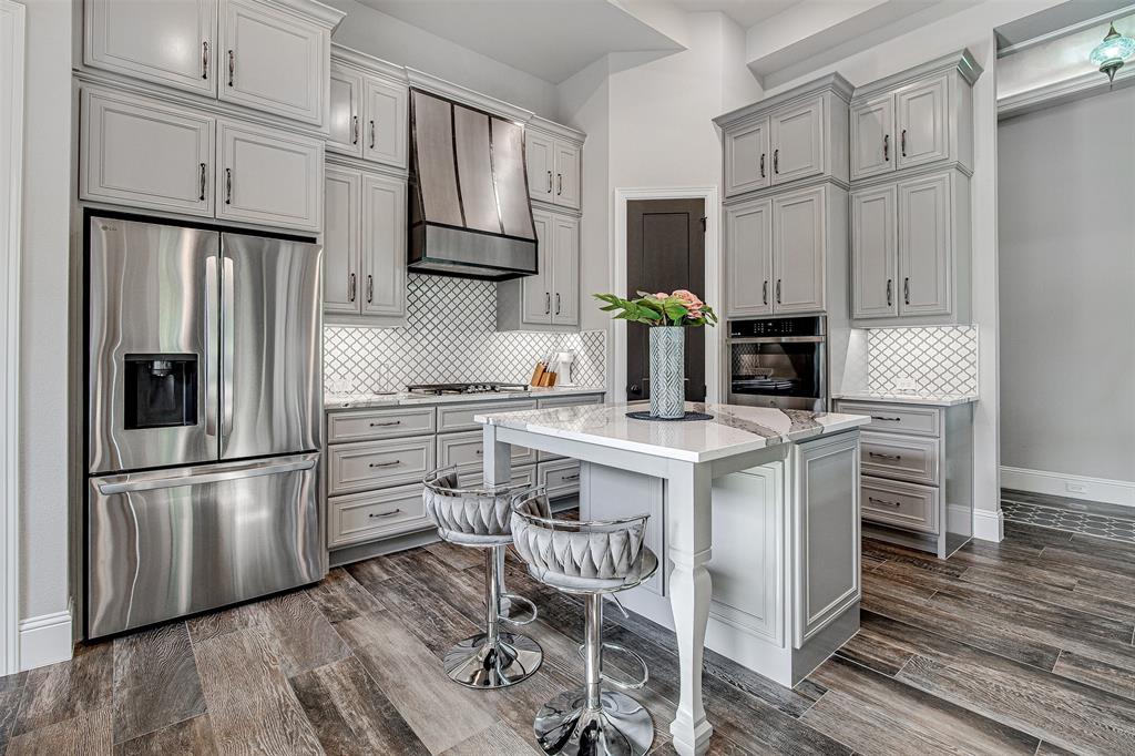 13924 East Riviera Drive Fort Worth, TX 76028 - Photo 12 of 38 a kitchen with stainless steel appliances a refrigerator stove microwave and cabinets