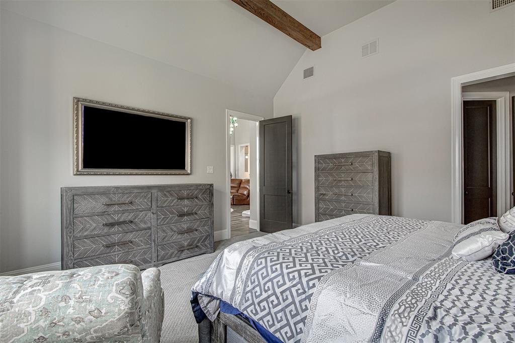 13924 East Riviera Drive Fort Worth, TX 76028 - Photo 19 of 38 a bedroom with a bed and a flat screen tv