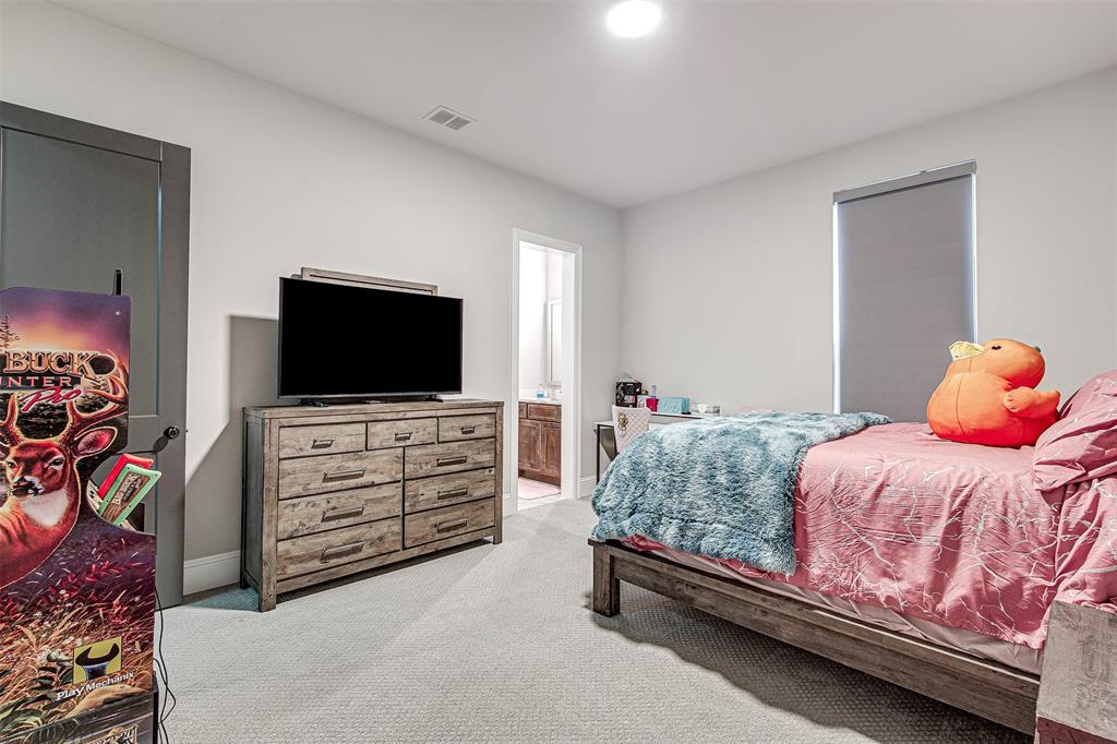 13924 East Riviera Drive Fort Worth, TX 76028 - Photo 25 of 38 a bedroom with a bed and a flat screen tv