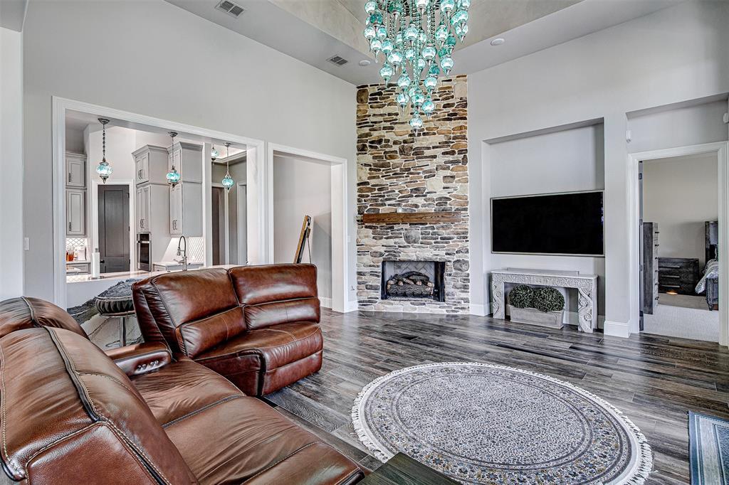 13924 East Riviera Drive Fort Worth, TX 76028 - Photo 8 of 38 a living room with furniture a flat screen tv and a fireplace