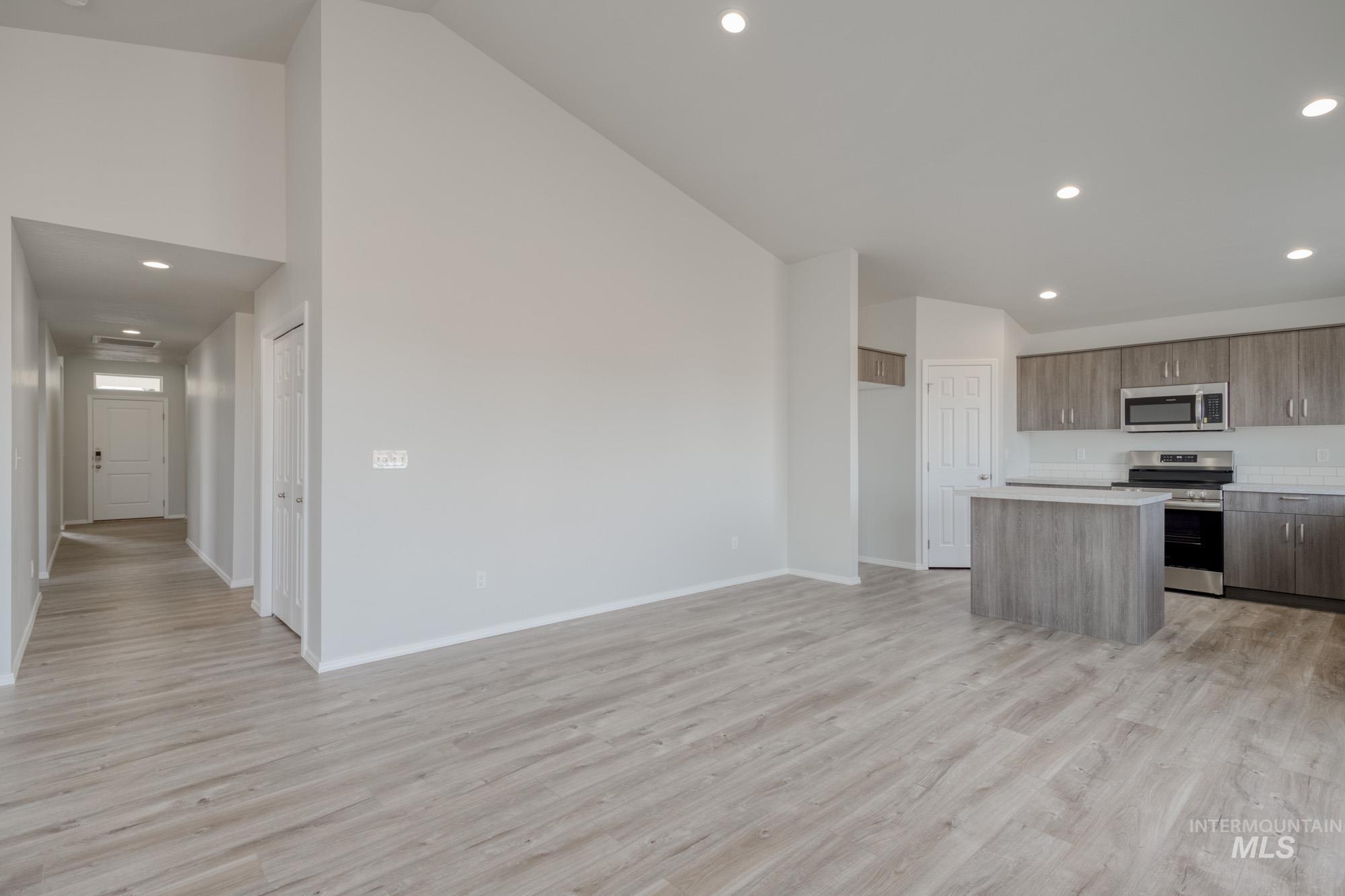 3150 South Maple Rnch Way Nampa, ID 83686 - Photo 10 of 22 Kitchen featuring a kitchen island, recessed lighting, appliances with stainless steel finishes, light wood-type flooring, and high vaulted ceiling
