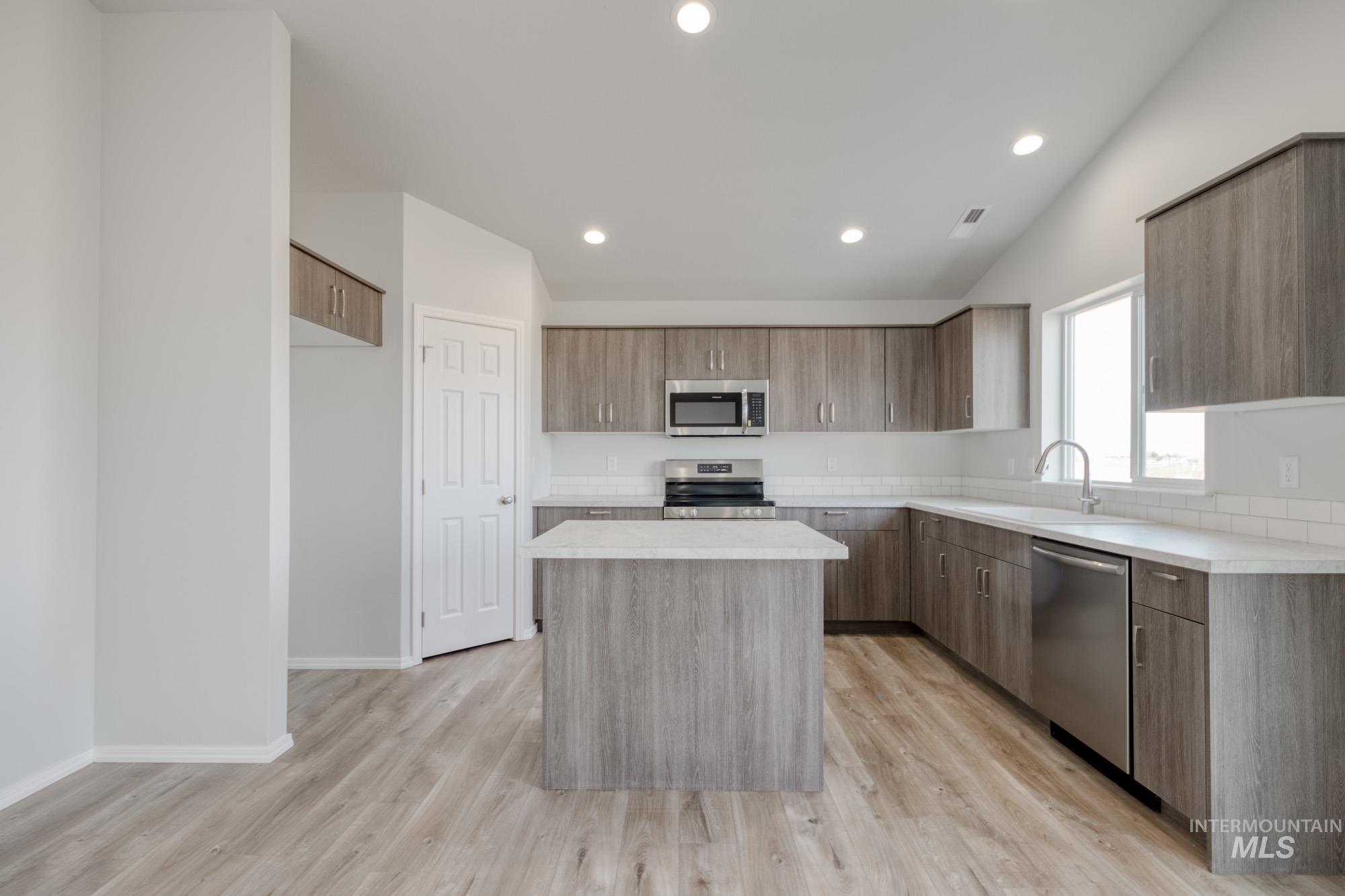 3150 South Maple Rnch Way Nampa, ID 83686 - Photo 3 of 22 Kitchen with light countertops, a kitchen island, modern cabinets, stainless steel appliances, and recessed lighting