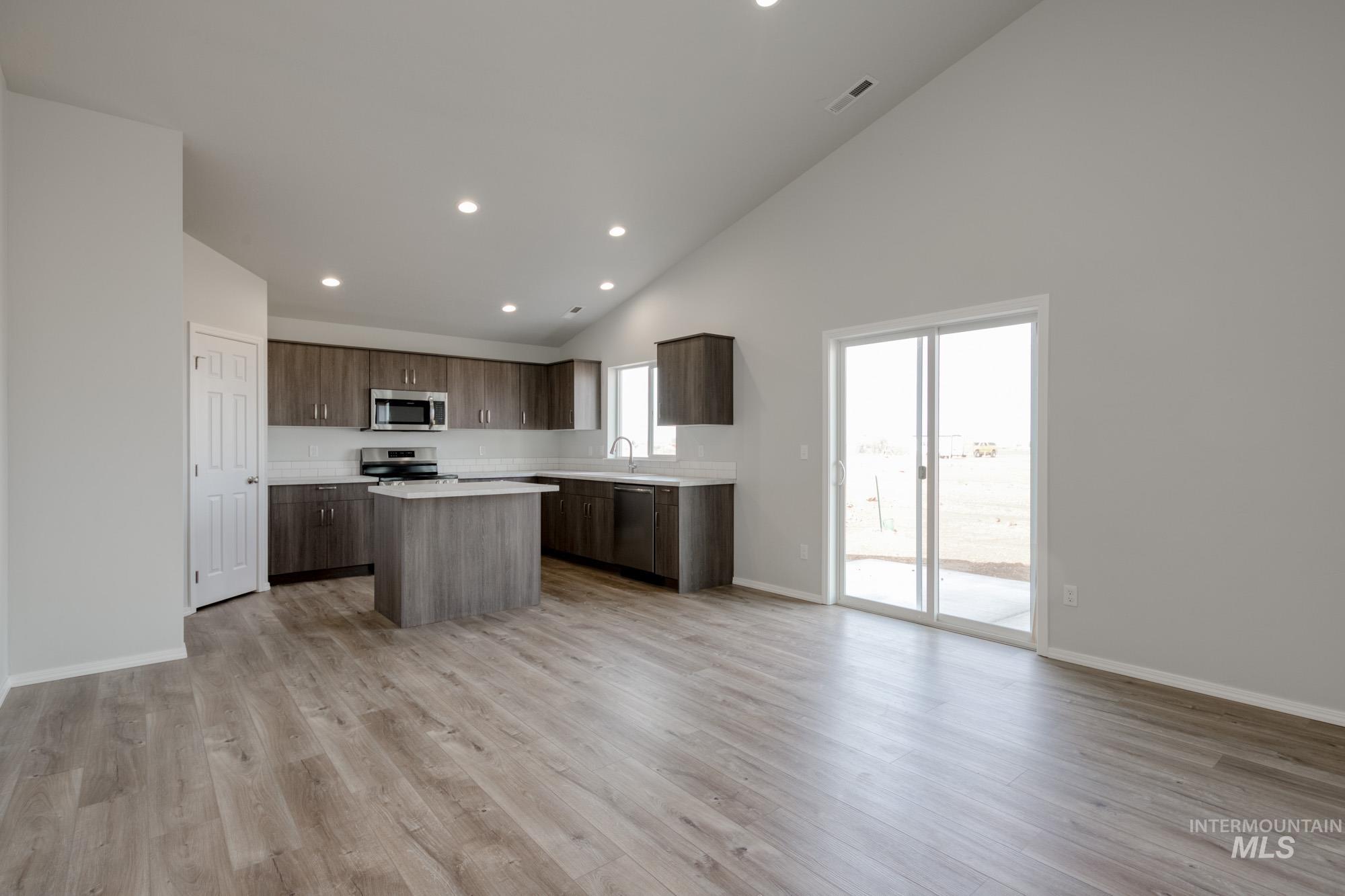 3150 South Maple Rnch Way Nampa, ID 83686 - Photo 22 of 22 Kitchen with open floor plan, light countertops, a center island, high vaulted ceiling, and light wood-type flooring