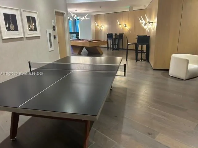 a room with pool table and wooden floor