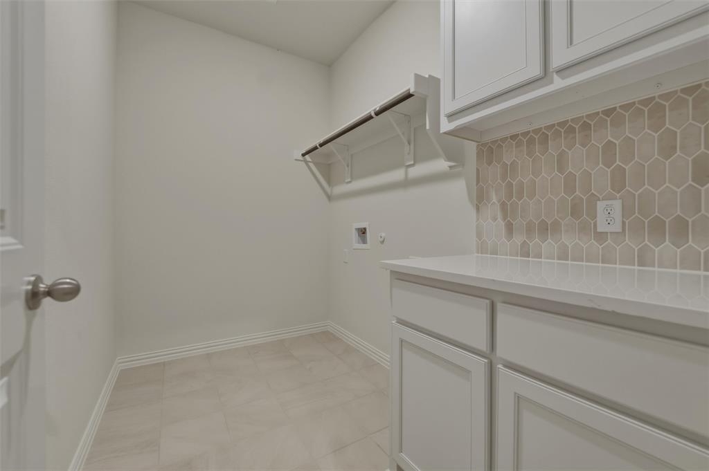 1113 Trinity Drive Springtown, TX 76082 - Photo 33 of 40 Neutral-toned tile flooring, built-in shelving, white cabinetry, integrated countertop, and geometric tile backsplash