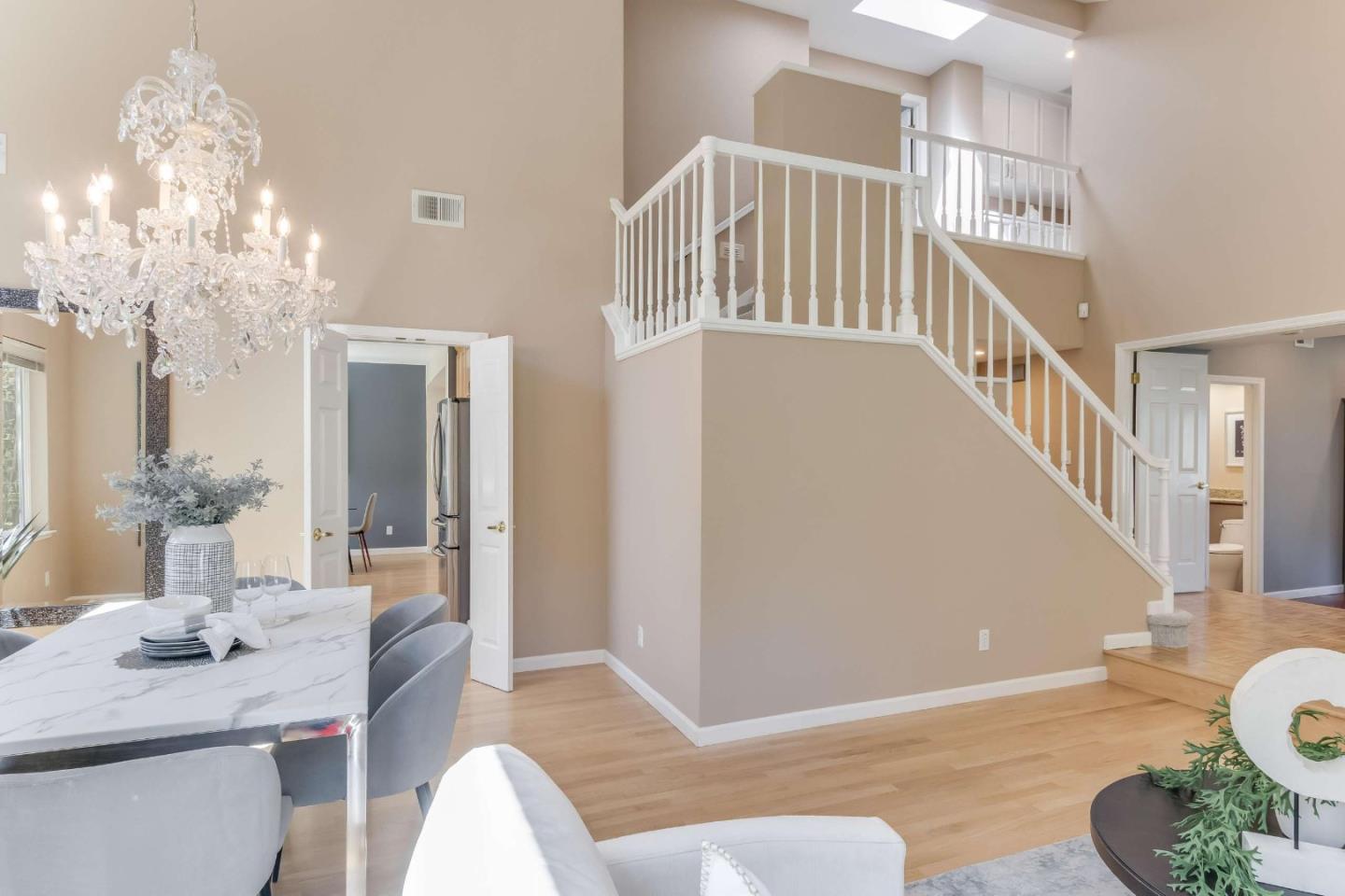 11627 Cedar Spring Court Cupertino, CA 95014 - Photo 5 of 54 a living room with couches chandelier and a dining table with wooden floor