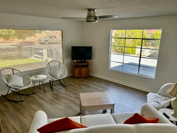 a living room with furniture a flat screen tv and a large window
