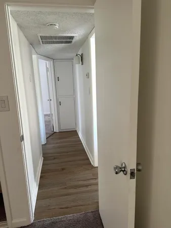 a view of a hallway with wooden floor and staircase