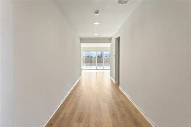 a view of a hallway with wooden floor