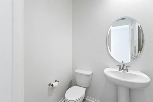 a bathroom with a toilet a sink and mirror