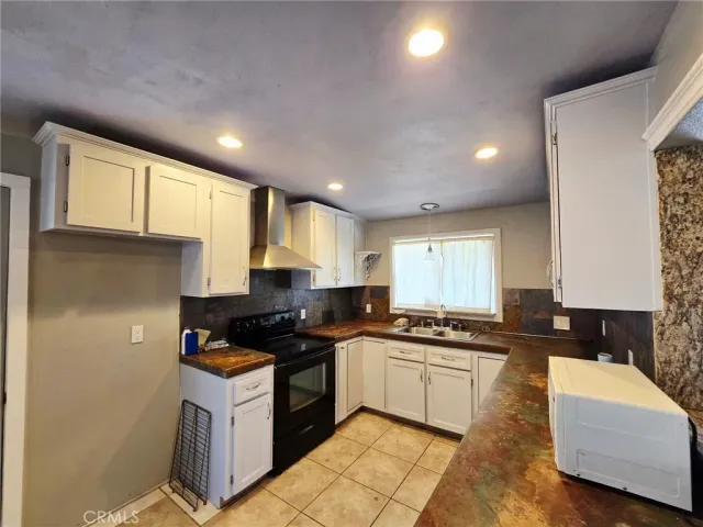 a kitchen with granite countertop a sink a counter top space and cabinets