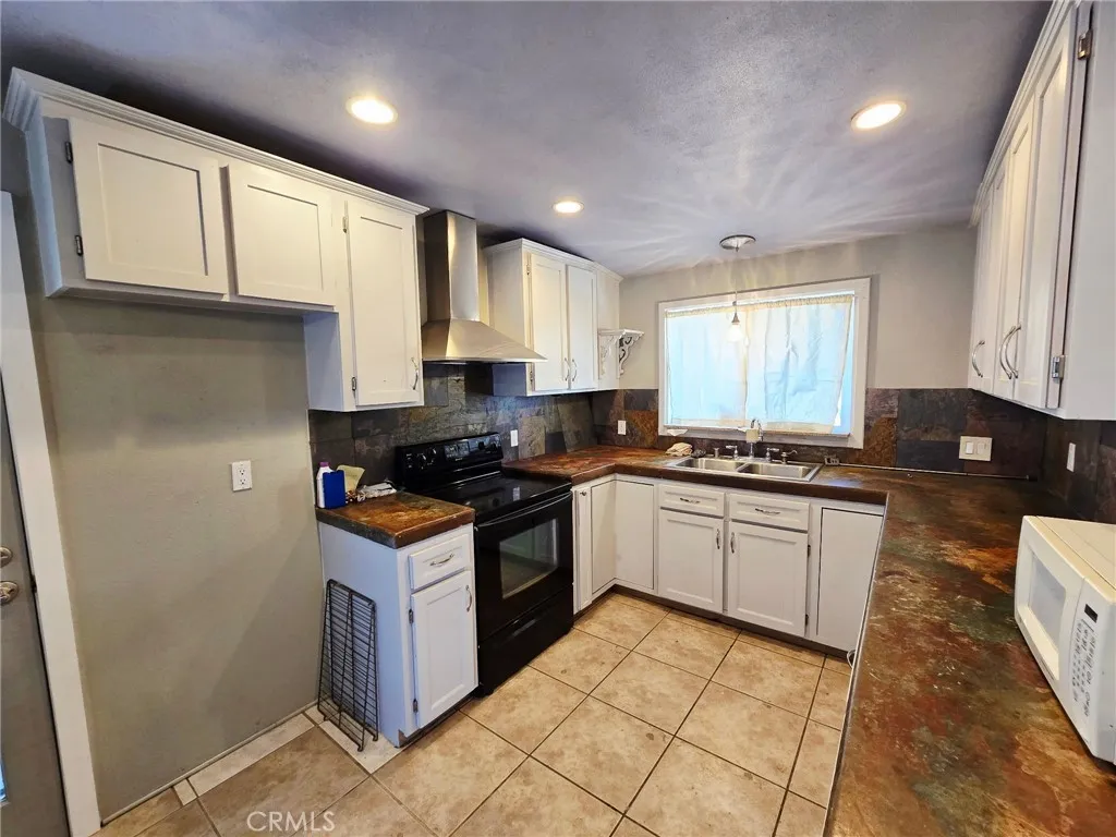 20221 Modoc Road Apple Valley, CA 92308 - Photo 5 of 23 a kitchen with stainless steel appliances granite countertop a stove a sink and a refrigerator