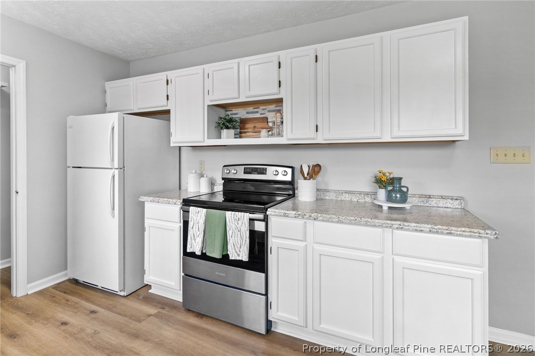 388 Woodwind Drive Spring Lake, NC 28390 - Photo 11 of 31 a kitchen with white cabinets and refrigerator
