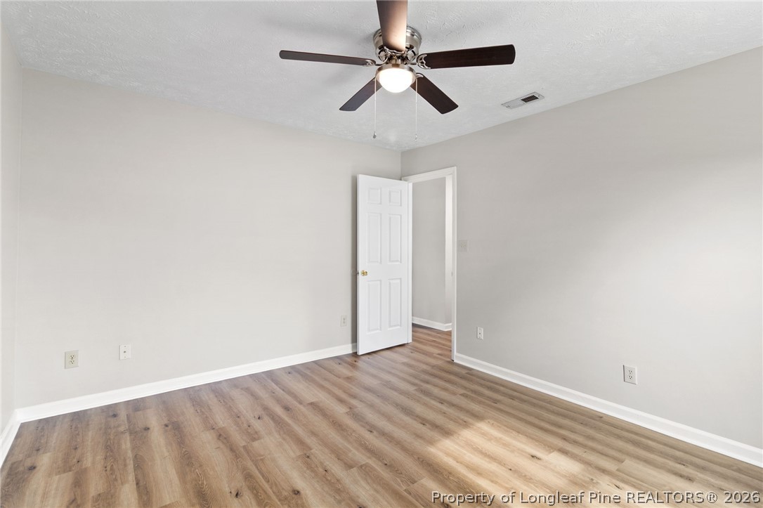388 Woodwind Drive Spring Lake, NC 28390 - Photo 16 of 31 an empty room with wooden floor ceiling fan and window