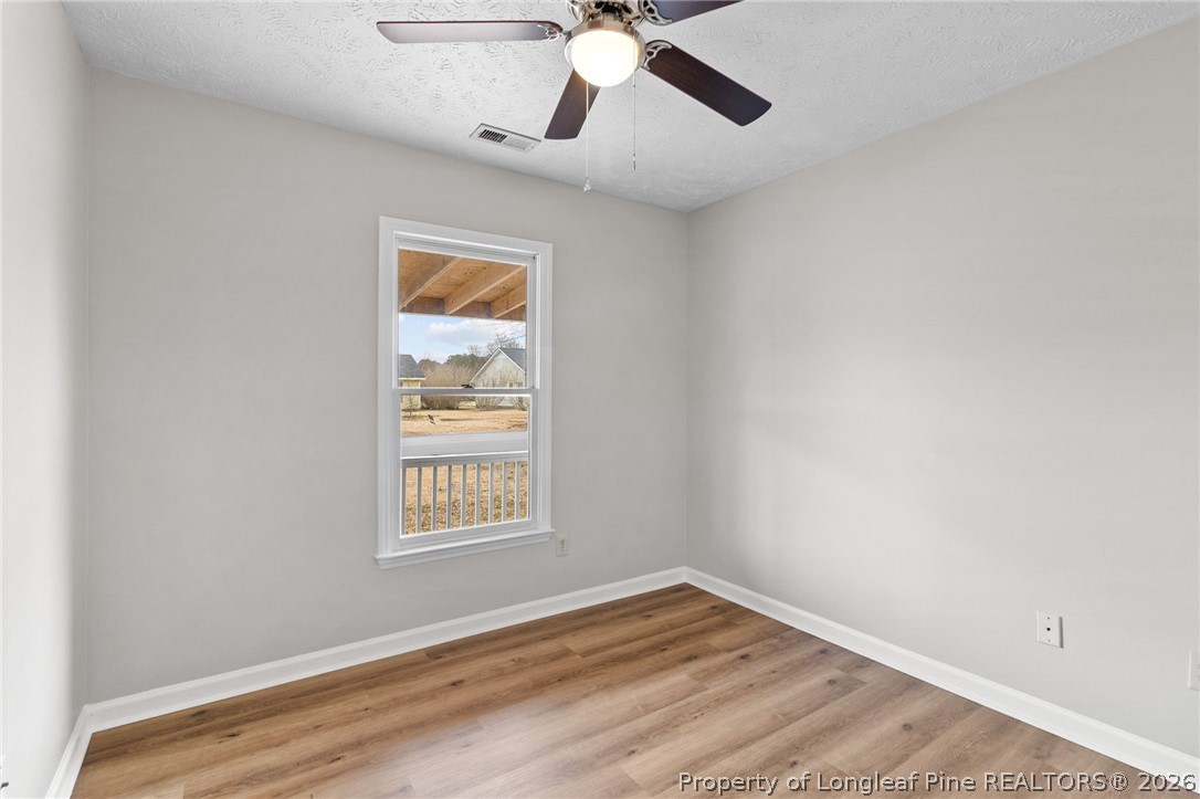 388 Woodwind Drive Spring Lake, NC 28390 - Photo 23 of 31 a view of an empty room with window and wooden floor