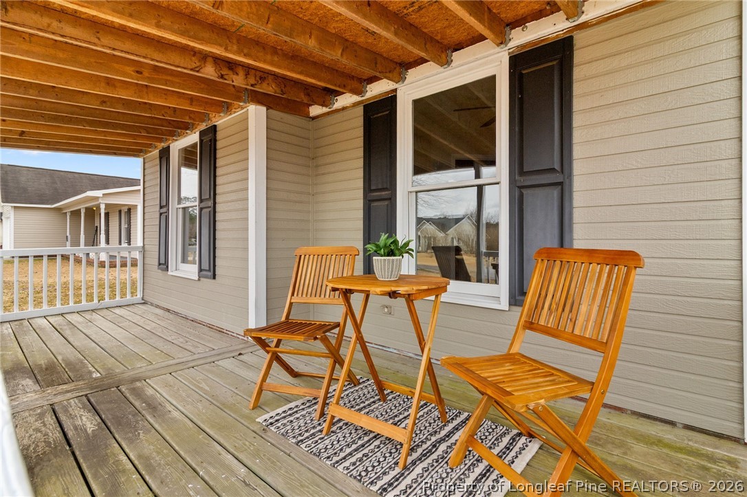 388 Woodwind Drive Spring Lake, NC 28390 - Photo 4 of 31 a view of a patio with table and chairs with wooden floor and fence