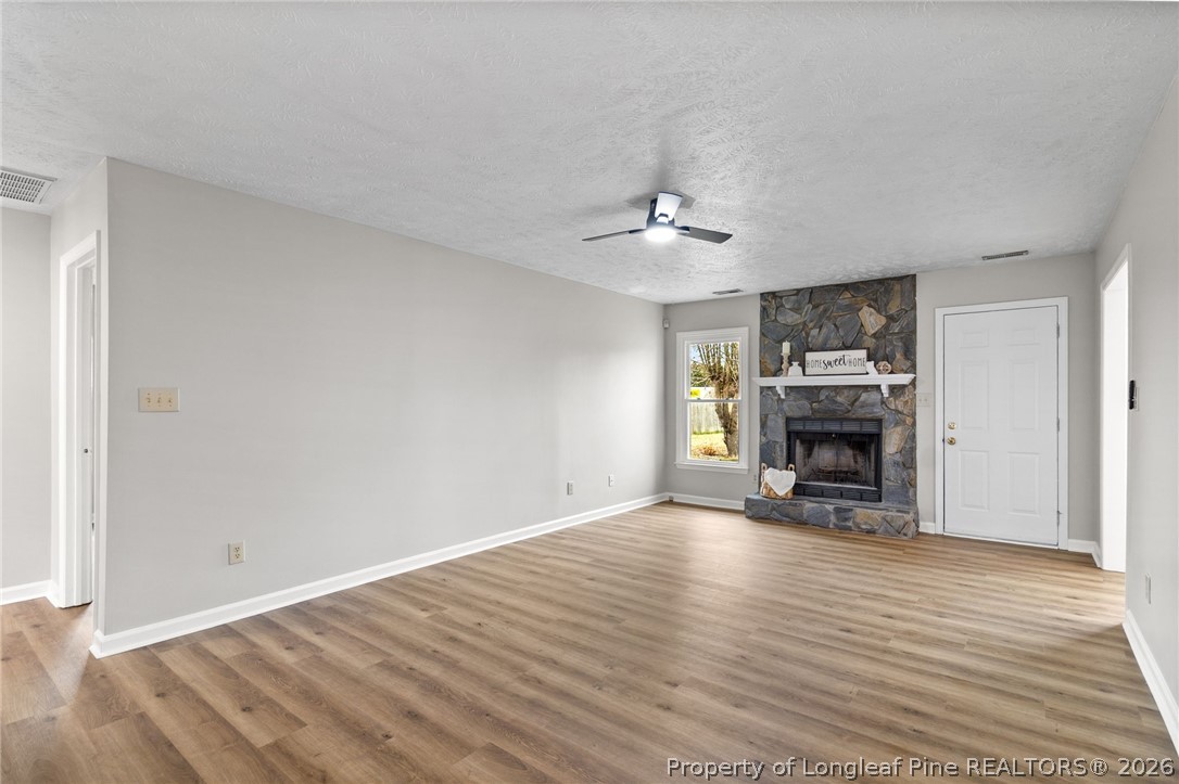 388 Woodwind Drive Spring Lake, NC 28390 - Photo 8 of 31 a view of empty room with fireplace and wooden floor
