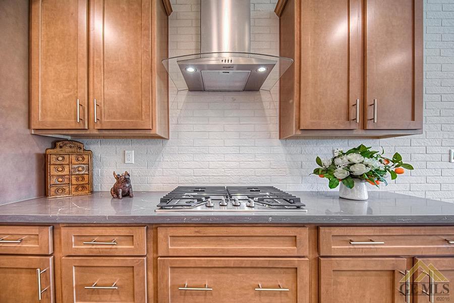 Undisclosed Address Bakersfield, CA 93311 - Photo 3 of 9 a kitchen with granite countertop white cabinets and potted plant