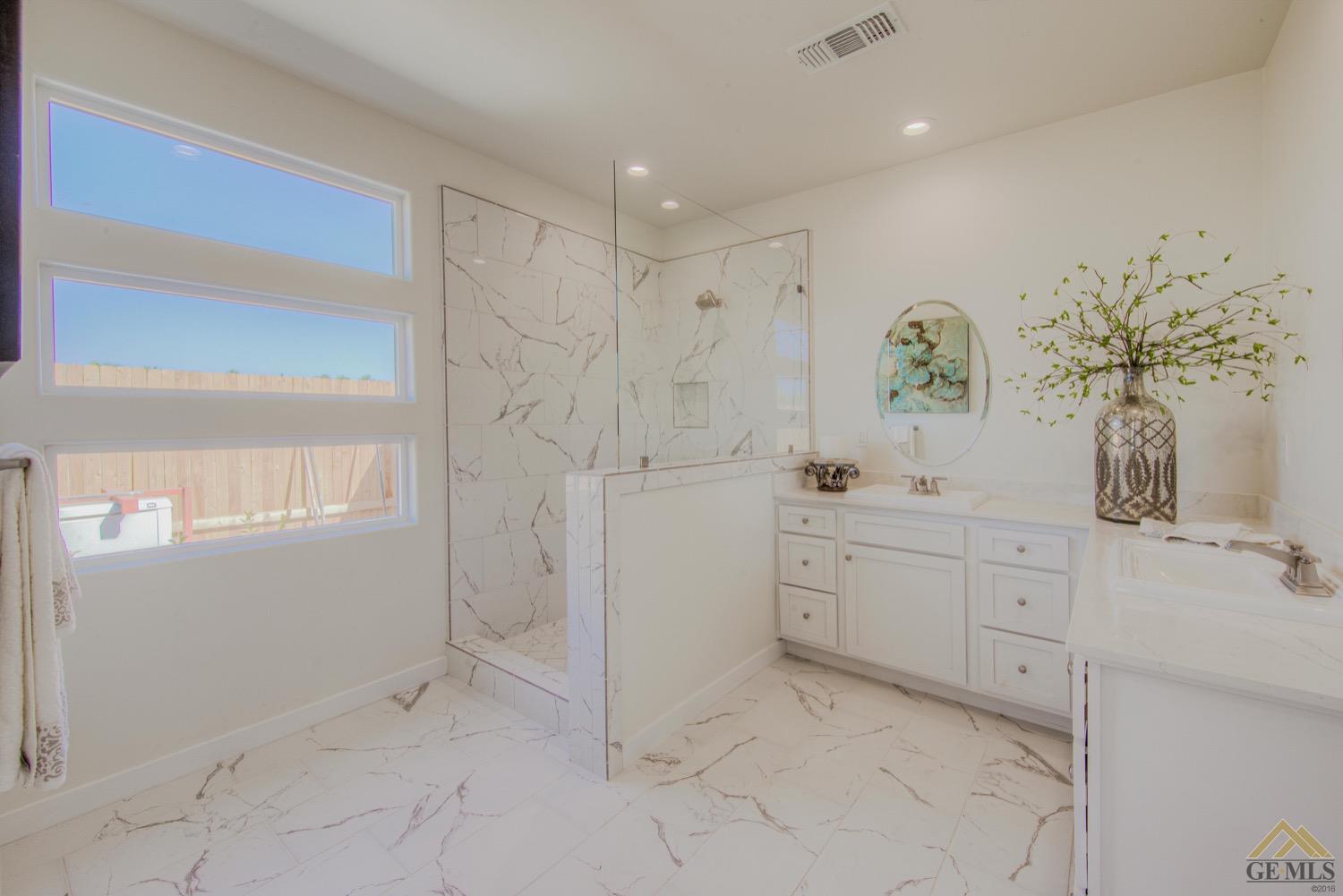 Undisclosed Address Bakersfield, CA 93311 - Photo 8 of 9 a spacious bathroom with a granite countertop sink a mirror and a bathtub