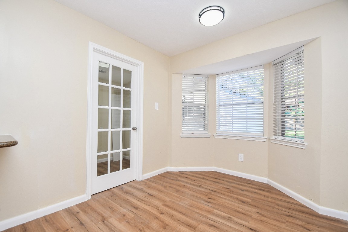 4730 Theall Road Houston, TX 77066 - Photo 11 of 32 an empty room with wooden floor and windows