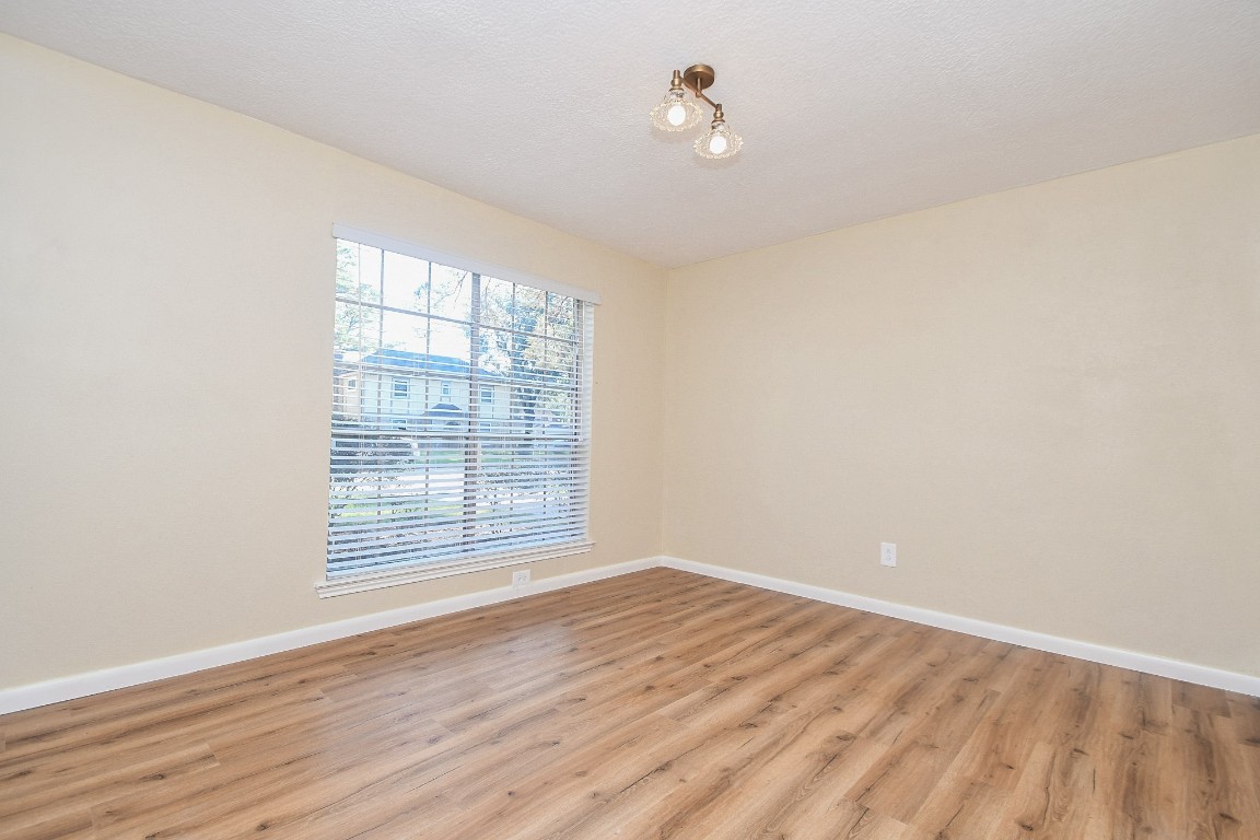 4730 Theall Road Houston, TX 77066 - Photo 23 of 32 wooden floor in an empty room with a window