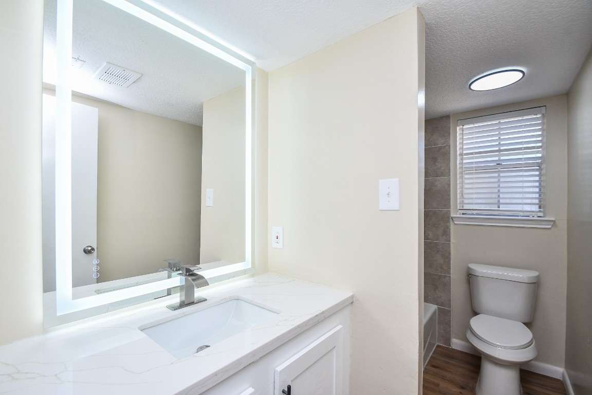 4730 Theall Road Houston, TX 77066 - Photo 24 of 32 a bathroom with a sink toilet and vanity