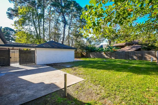 a front view of a house with a yard and a large tree