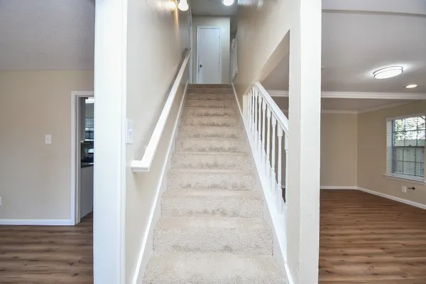 a view of staircase with white walls and wooden floor