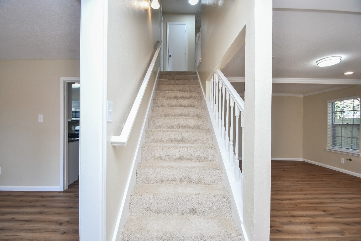 4730 Theall Road Houston, TX 77066 - Photo 4 of 32 a view of staircase with white walls and wooden floor