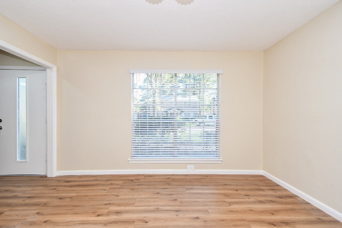 4730 Theall Road Houston, TX 77066 - Photo 5 of 32 a view of an empty room with wooden floor and a window