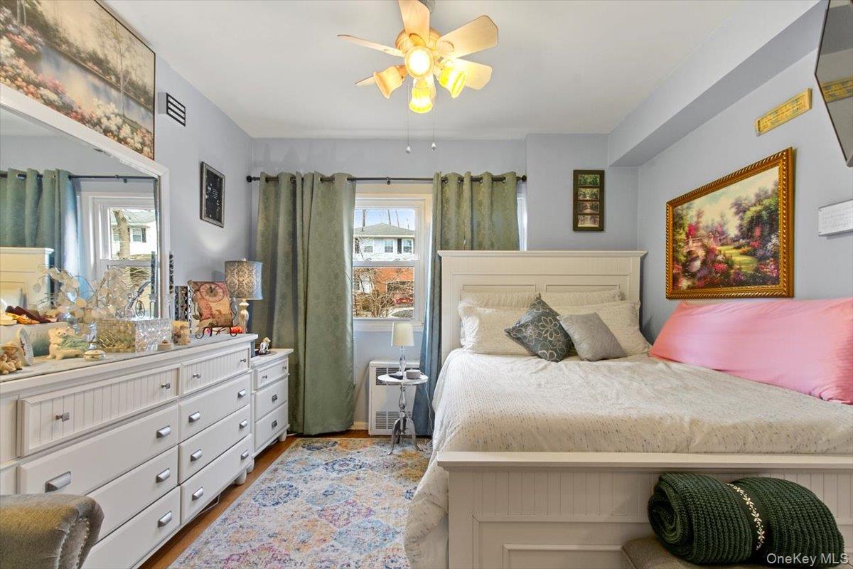 103 Wiltshire Road, Unit D11 Scarsdale, NY 10583 - Photo 10 of 23 a bedroom with a bed and a chandelier