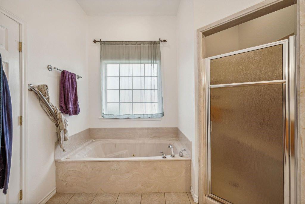 641 Comanche Lake Road Comanche, TX 76442 - Photo 17 of 34 a bathroom with a bathtub and a shower