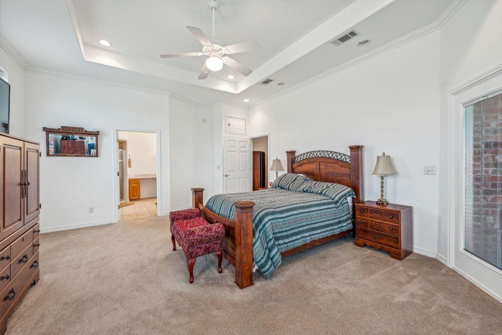 641 Comanche Lake Road Comanche, TX 76442 - Photo 19 of 34 a bedroom with a bed and a chandelier