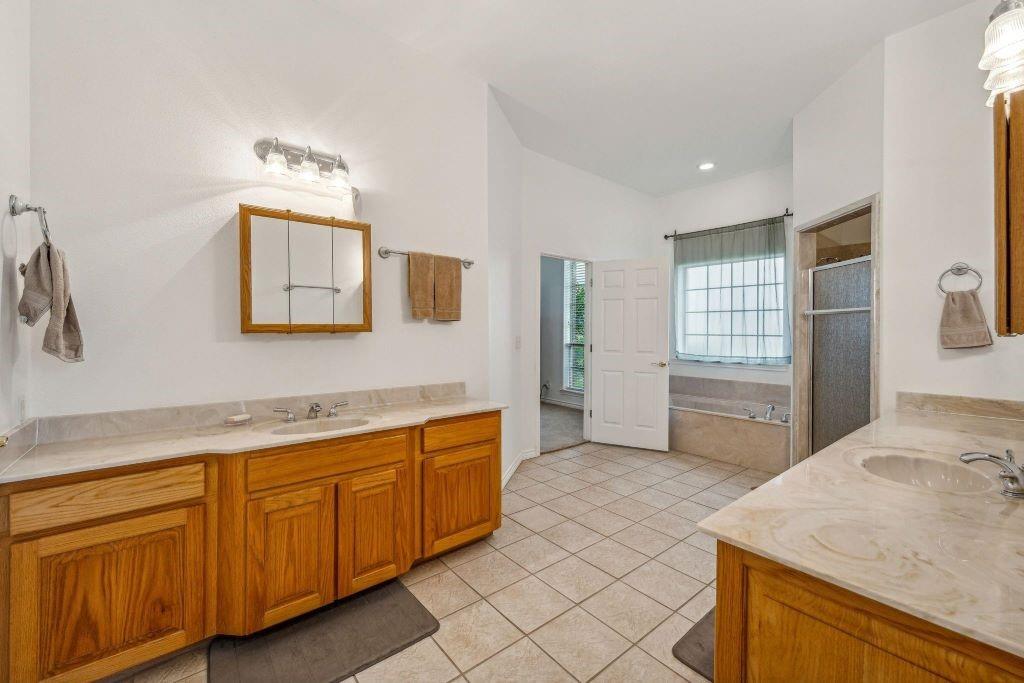 641 Comanche Lake Road Comanche, TX 76442 - Photo 20 of 34 a spacious bathroom with a granite countertop sink a mirror and a bathtub