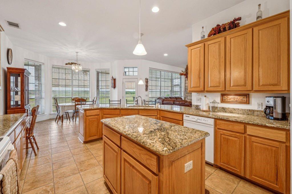 641 Comanche Lake Road Comanche, TX 76442 - Photo 9 of 34 a kitchen with stainless steel appliances granite countertop a stove a sink and a refrigerator