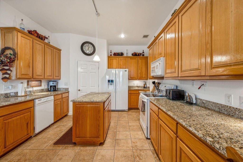 641 Comanche Lake Road Comanche, TX 76442 - Photo 10 of 34 a kitchen with stainless steel appliances granite countertop wooden cabinets a sink and a stove