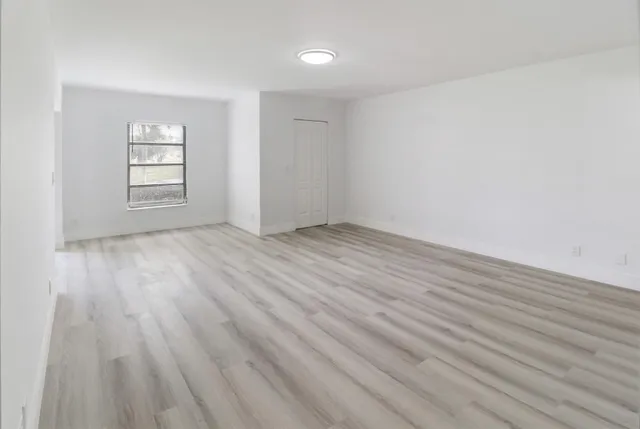 wooden floor in an empty room with a window