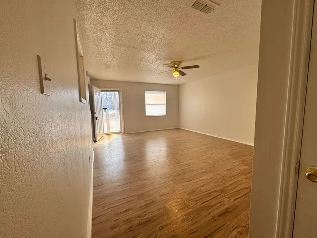 a view of hallway with stairs and wooden floor