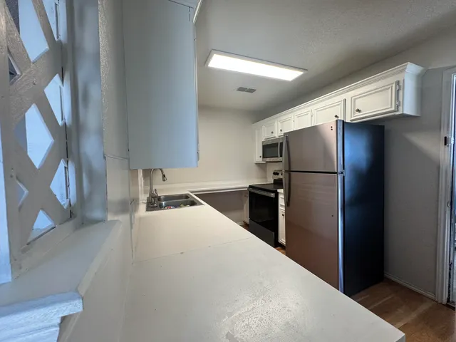 a kitchen with a refrigerator and a sink