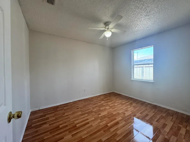 a view of a room with wooden floor and fan