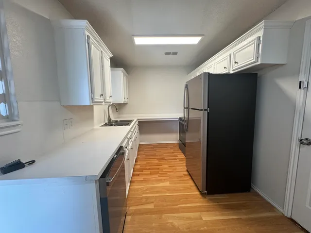 a kitchen with granite countertop a refrigerator and a sink