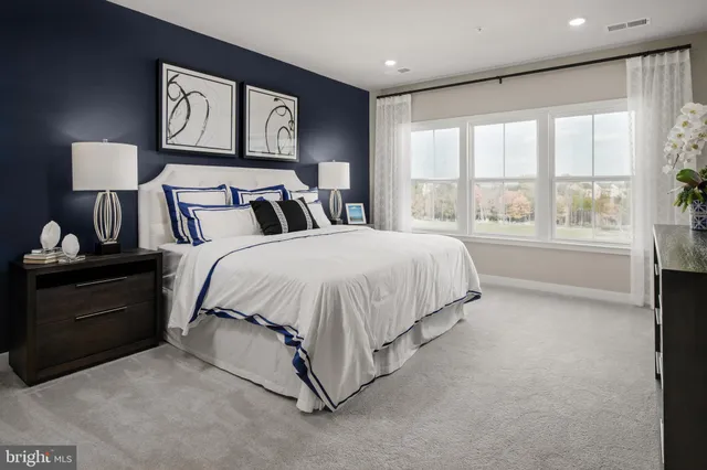 a spacious bedroom with a bed and a night stand