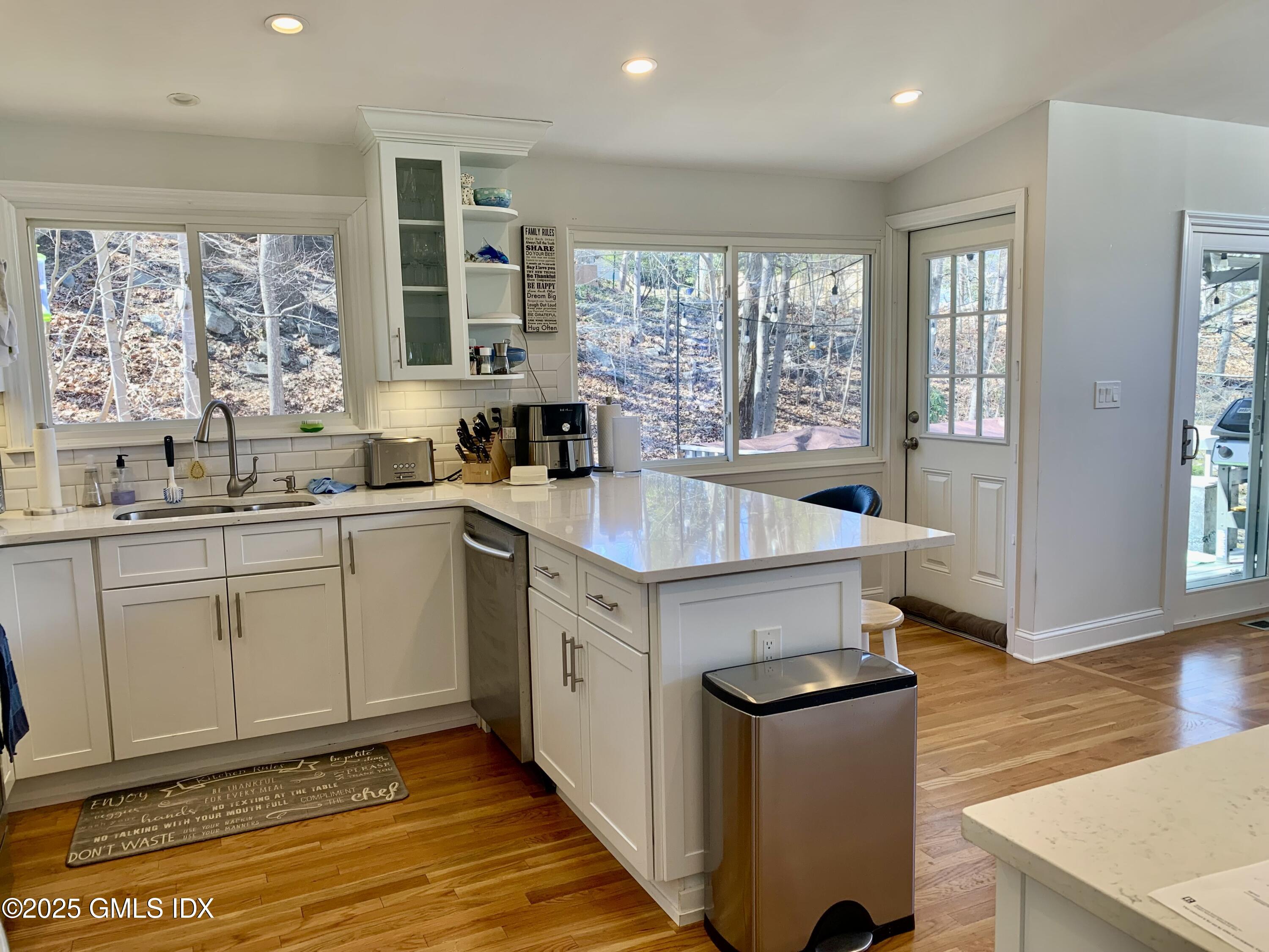 67 Florence Road Riverside, CT 06878 - Photo 2 of 23 a kitchen with sink a stove and white cabinets with wooden floor