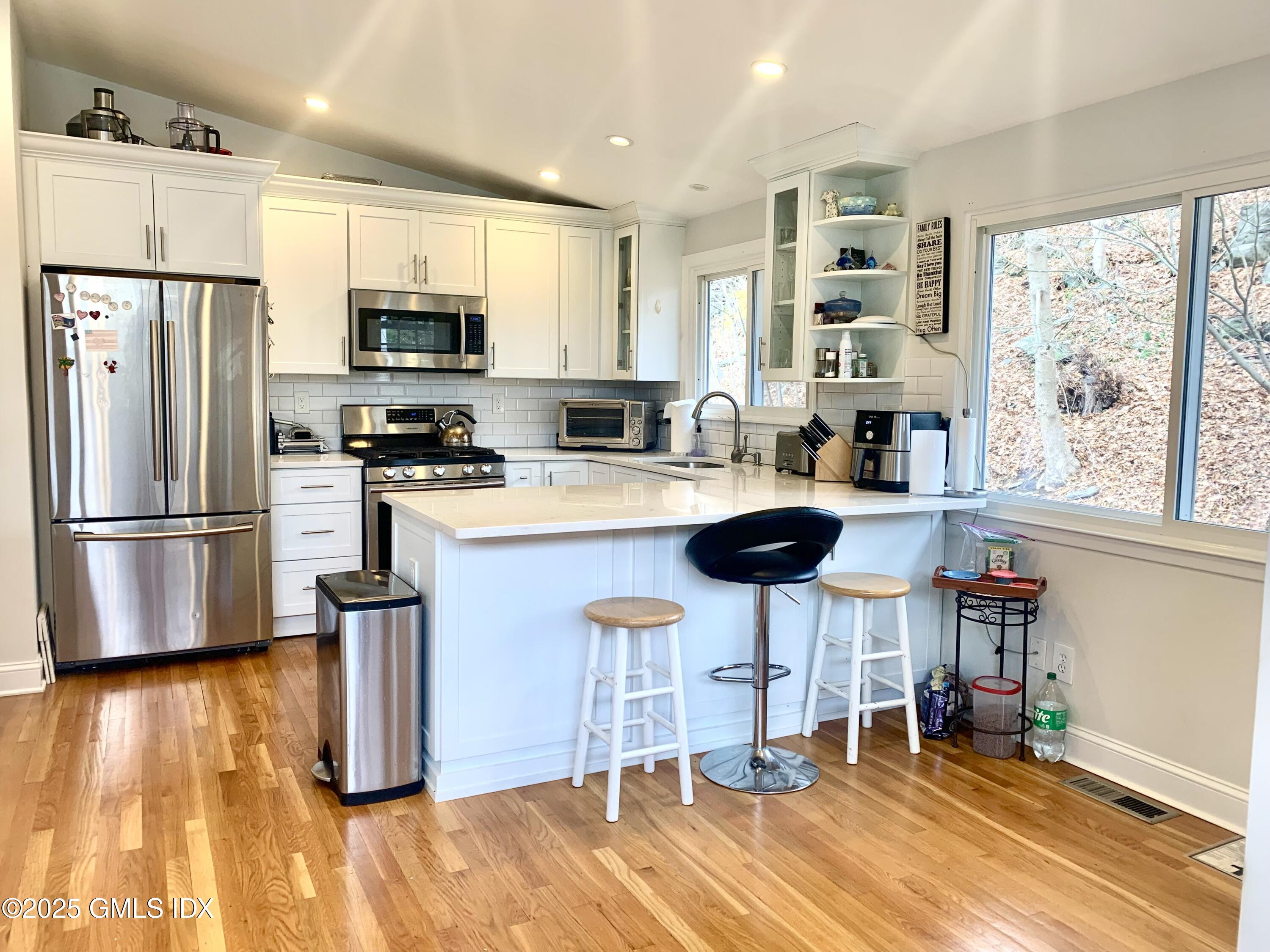 67 Florence Road Riverside, CT 06878 - Photo 3 of 23 a kitchen with stainless steel appliances a stove a refrigerator and wooden cabinets with wooden floor