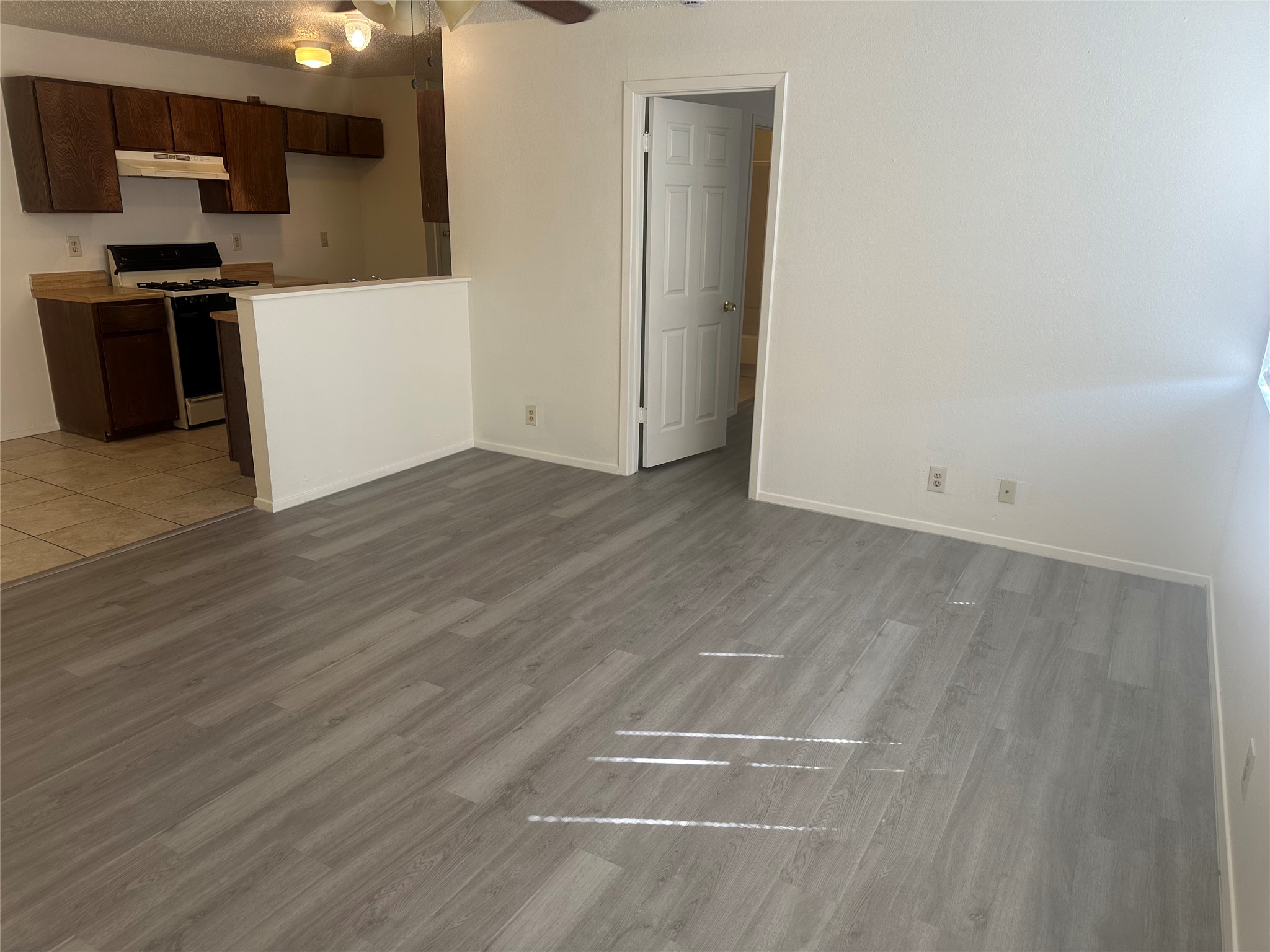 2602 South Bagdad Road, Unit B Leander, TX 78641 - Photo 22 of 23 An open floorplan seamlessly connects the wood-plank flooring of the main room to the kitchen.