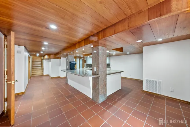 a spacious bedroom with a bed and wooden floor